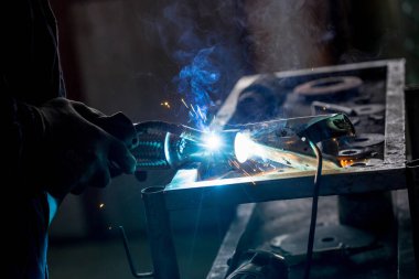 Erkek işçi araba egzoz boru kaynak makinesi ile kısayollarımı koruyucu eldivenler