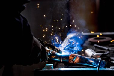 Erkek işçi araba egzoz boru kaynak makinesi ile kısayollarımı koruyucu eldivenler