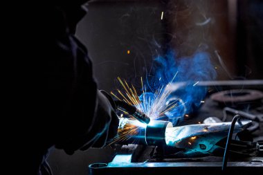 Erkek işçi araba egzoz boru kaynak makinesi ile kısayollarımı koruyucu eldivenler