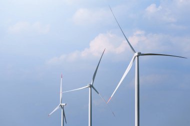 Yel değirmeni türbin grubu mavi gökyüzünde parçalı bulutlu: arka plan ile. Yenilenebilir enerji rüzgar türbinleri