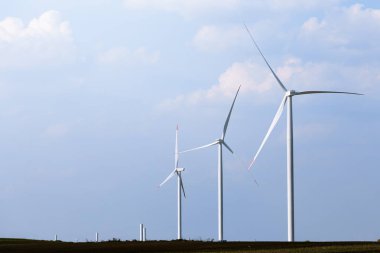 Yel değirmeni türbin grubu mavi gökyüzünde parçalı bulutlu: arka plan ile. Yenilenebilir enerji rüzgar türbinleri