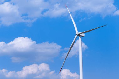 Yel değirmeni türbin grubu mavi gökyüzünde parçalı bulutlu: arka plan ile. Yenilenebilir enerji rüzgar türbinleri