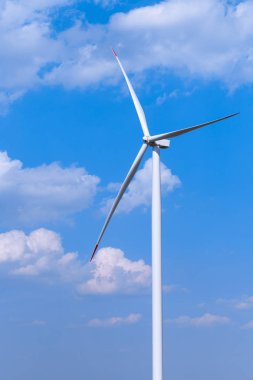 Arka planda parçalı bulutlu mavi gökyüzü ile bir tek rüzgar türbini türbin. Yenilenebilir enerji rüzgar türbini