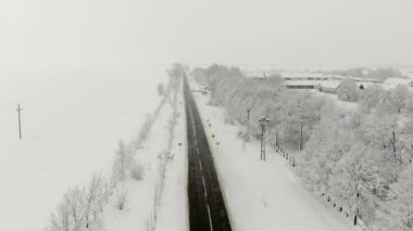 Köy dron 4k hava görüntülerini karla kaplı. Beyaz bulutlu kış hava.