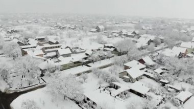 Köy dron 4k hava görüntülerini karla kaplı. Beyaz bulutlu kış hava.