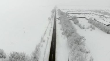 Köy dron 4k hava görüntülerini karla kaplı. Beyaz bulutlu kış hava.