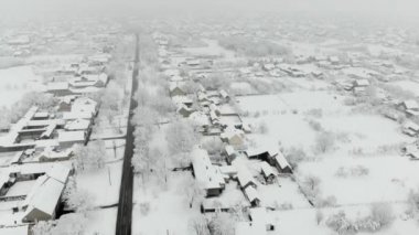 Köy dron 4k hava görüntülerini karla kaplı. Beyaz bulutlu kış hava.