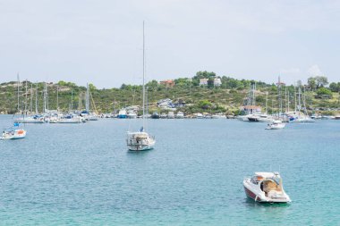 Bir sürü şehir dışında bir limanda demirli yelkenliler.