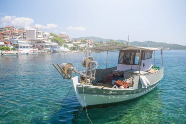 Kasaba dokta yanında beyaz balıkçı teknesi demirli.