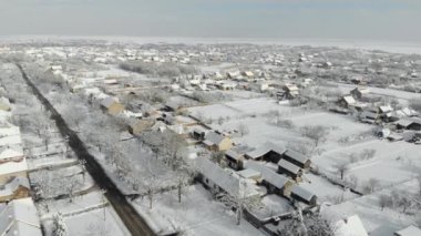 Uçak 4k düz köyde hava görüntülerini karla kaplı. Beyaz bulutlu kış hava.