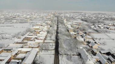 Uçak 4k düz köyde hava görüntülerini karla kaplı. Beyaz bulutlu kış hava.