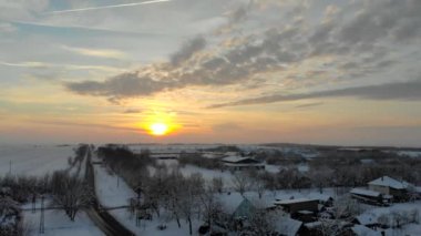 Uçak 4k düz köyde hava görüntülerini karla kaplı. Beyaz bulutlu kış hava.