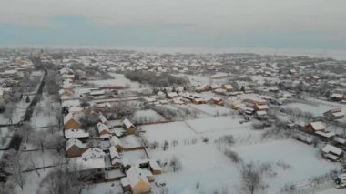 Uçak 4k düz köyde hava görüntülerini karla kaplı. Beyaz bulutlu kış hava.