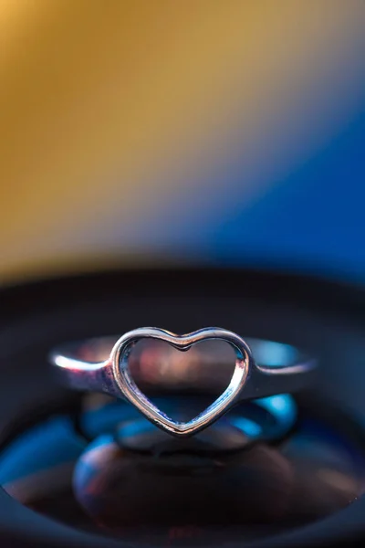 Anillo Forma Corazón Plata Con Fondo Azul Amarillo —  Fotos de Stock