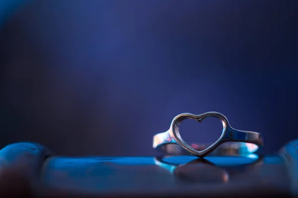 Silberner Herzförmiger Ring Mit Blauem Hintergrund — Stockfoto