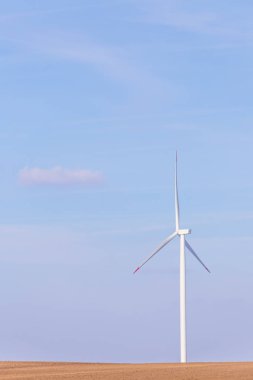 Rüzgar Türbini türbin arka planda parçalı bulutlu mavi gökyüzü ile. Yenilenebilir enerji Rüzgar türbinleri