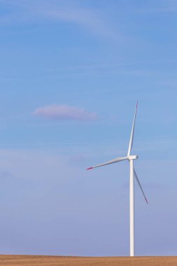 Rüzgar Türbini türbin arka planda parçalı bulutlu mavi gökyüzü ile. Yenilenebilir enerji Rüzgar türbinleri