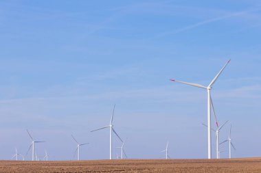 Yel değirmeni türbin grubu mavi gökyüzünde parçalı bulutlu: arka plan ile. Yenilenebilir enerji rüzgar türbinleri
