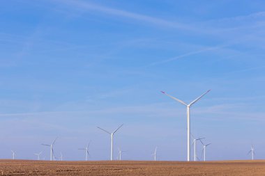 Yel değirmeni türbin grubu mavi gökyüzünde parçalı bulutlu: arka plan ile. Yenilenebilir enerji rüzgar türbinleri