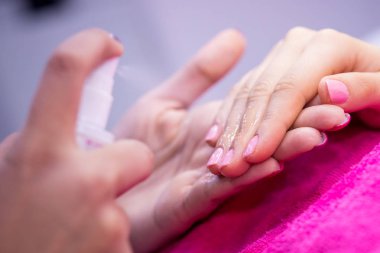 Kadınların elleri üzerinde tırnak salonu pembe havlu.