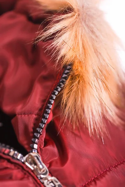 Närbild av blixtlås på röd jacka med päls, vinter mode outfit. Jacka isolerad på vit bakgrund. — Stockfoto
