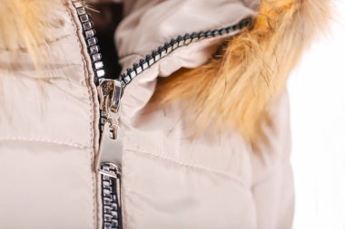 Fermuar üstünde kürk, Kış moda kıyafet ile bej ceketi, yakın çekim. Beyaz arka plan üzerinde izole ceket. Fermuar üstünde kürk, Kış moda kıyafet ile bej ceketi, yakın çekim. Beyaz bac izole ceket