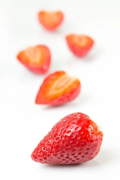 Coupe rouge fraîche et fraises entières disposées sur un fond blanc . — Photo