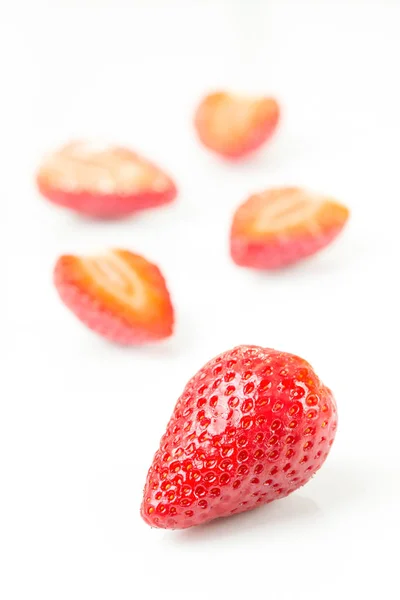 Red fresh cut and whole strawberries arranged on a white background.strawberry, food, ripe, organic, white, red, background, fruit, fresh, isolated, berry, juicy, freshness, closeup, object, macro, ha — Stock Photo, Image