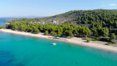 Ağaçlarla çevrili kumlu plajda mavi deniz yüzeyinin havadan drone görünümü. Şeffaf turkuaz okyanus su yüzeyi, deniz kıyısı, orman üst görünümü.
