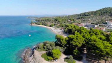 Ağaçlarla çevrili kumlu plajda mavi deniz yüzeyinin havadan drone görünümü. Şeffaf turkuaz okyanus su yüzeyi, deniz kıyısı, orman üst görünümü.