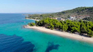 Ağaçlarla çevrili kumlu plajda mavi deniz yüzeyinin havadan drone görünümü. Şeffaf turkuaz okyanus su yüzeyi, deniz kıyısı, orman üst görünümü.