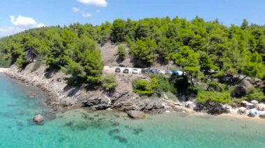 Ağaçlarla çevrili kumlu plajda mavi deniz yüzeyinin havadan drone görünümü. Şeffaf turkuaz okyanus su yüzeyi, deniz kıyısı, orman üst görünümü.