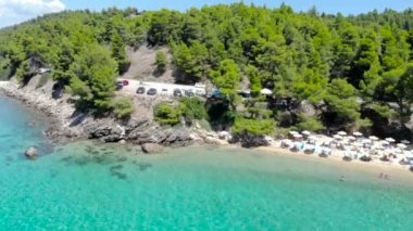 Ağaçlarla çevrili kumlu plajda mavi deniz yüzeyinin havadan drone görünümü. Şeffaf turkuaz okyanus su yüzeyi, deniz kıyısı, orman üst görünümü.