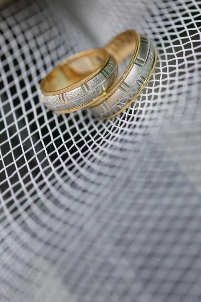 Anéis de casamento dourados na malha branca — Fotografia de Stock