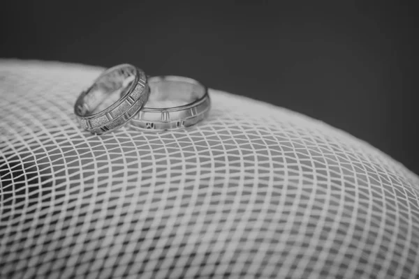 Anillos de boda dorados en la malla blanca —  Fotos de Stock