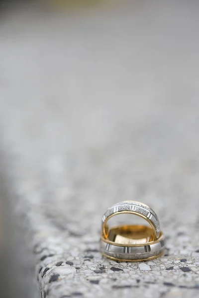Anéis de casamento dourados em uma superfície de pedra — Fotografia de Stock