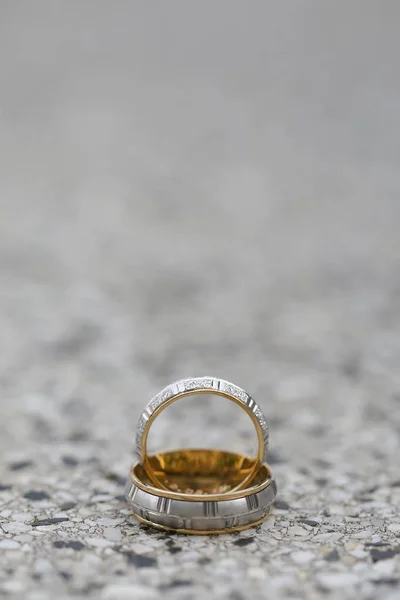 Anneaux de mariage dorés sur une surface de pierre — Photo
