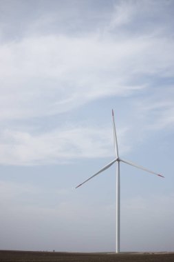 Arka planda bulutlu gökyüzü ile tarım salkÄ±mÄ±nda bir rüzgar türbini