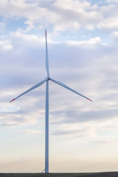 Ein Windrad auf landwirtschaftlichem Boden mit bewölktem Himmel im Hintergrund — Stockfoto