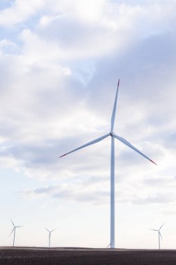 arka planda bulutlu gökyüzü ile rüzgar türbini