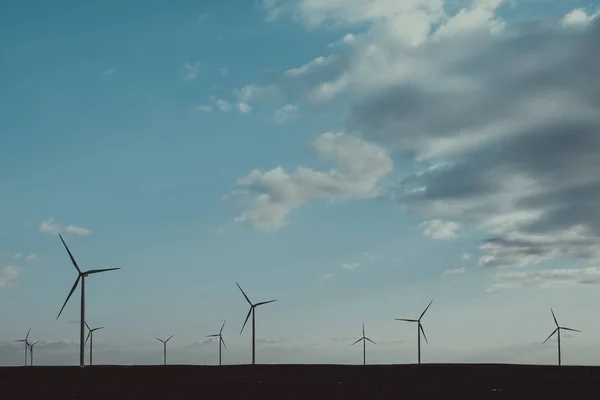 Wind warm on agricultural ground with cloudy sky in background