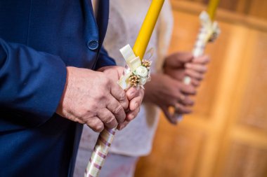 Ortodoks Kilisesi'nde düğün töreni sırasında mum tutan yaşlı adam elleri