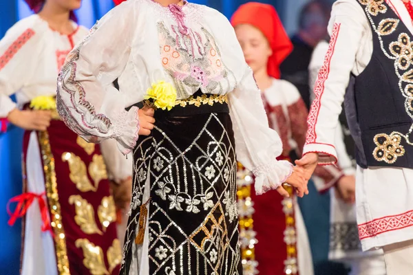Gros plan des mains de jeunes danseurs roumains exécutent une danse folklorique en costume folklorique traditionnel. Folklore de Roumanie — Photo