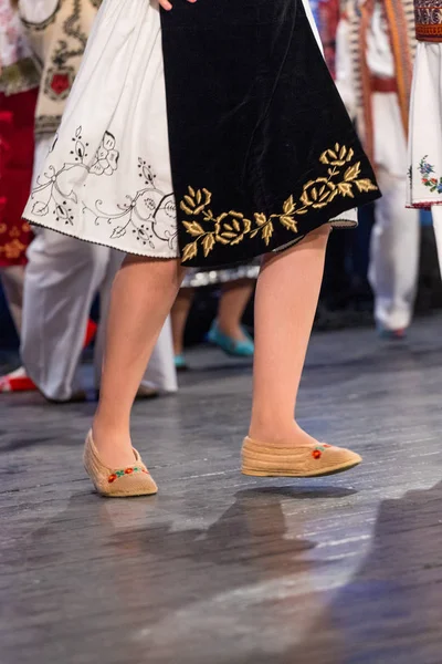 Blízko nohou mladých rumunských tanečníků se v tradičním folklorním kostýmu provádí folkový tanec. Folklór Rumunska — Stock fotografie