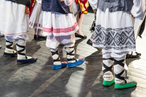Gros plan des jambes de jeunes danseurs roumains exécutent une danse folklorique en costume folklorique traditionnel. Folklore de Roumanie — Photo