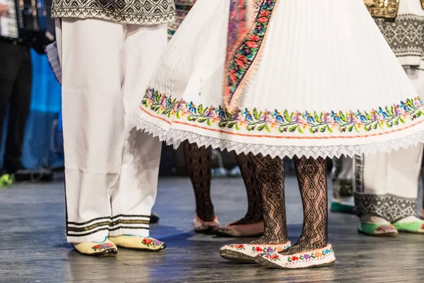 Close-up van de benen van jonge Roemeense dansers voeren een volksdans in traditionele folkloristische kostuum. Folklore van Roemenië — Stockfoto