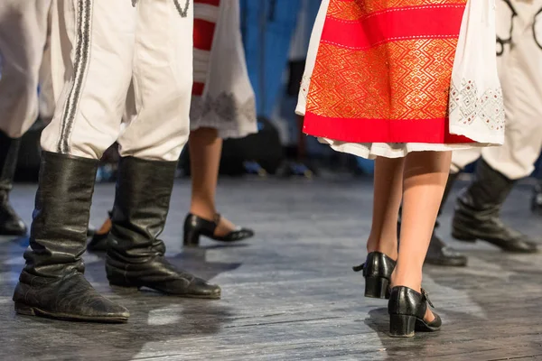 Close up de pernas de jovens dançarinos romenos realizar uma dança folclórica em traje folclórico tradicional. Folclore da Roménia — Fotografia de Stock