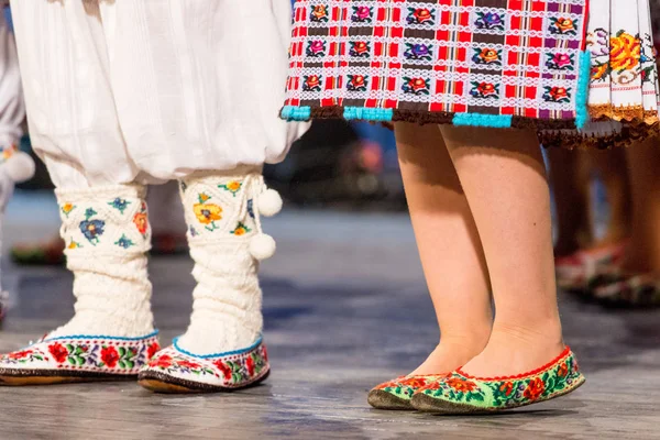 Крупным планом ноги молодых румынских танцоров исполняют народный танец в традиционном фольклорном костюме. Фольклор Румынии — стоковое фото