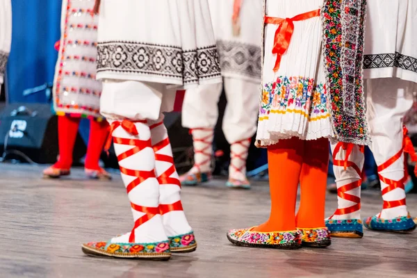 Bliska nogi młodych rumuńskich tancerzy wykonują taniec ludowy w tradycyjnym stroju folklorystycznego. Folklor Rumunii — Zdjęcie stockowe