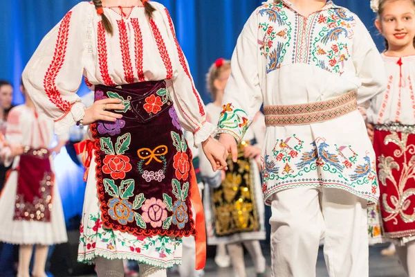 Молоді румунські танцюристи виконують народний танець у традиційному фольклориному костюмі. Фольклор Румунії — стокове фото